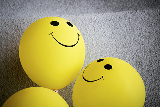 Yellow balloons with smiling faces on them