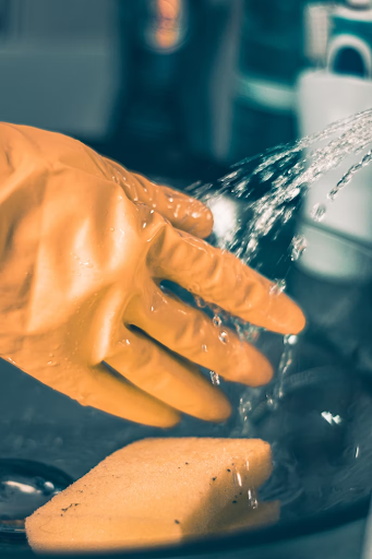 A hand wearing a yellow glove