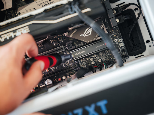 A person using a screwdriver to modify a PC