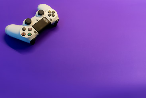 A white gaming controller on a purple surface