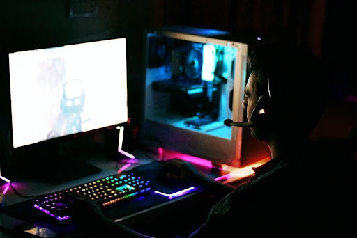 A gamer playing on a setup that has RGB parts and accessories, including an RGB mouse pad.